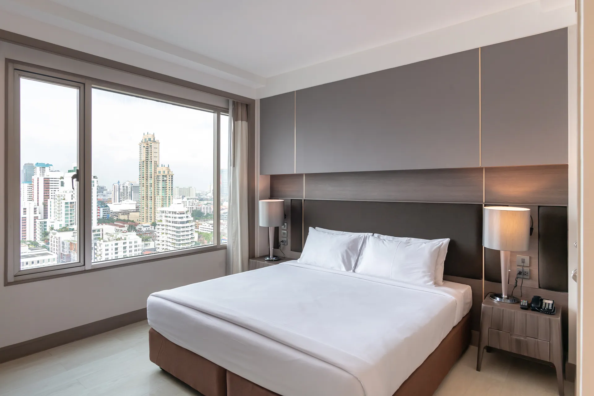 Modern design of a 2-bedroom suite with kitchen at a Bangkok hotel.