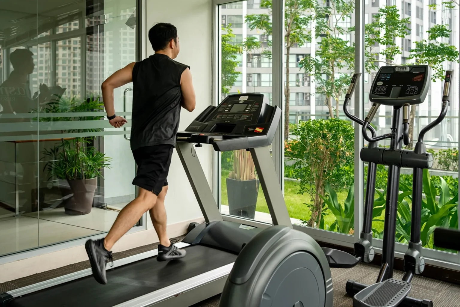A gym with Bangkok city view at a hotel with modern fitness facilities.