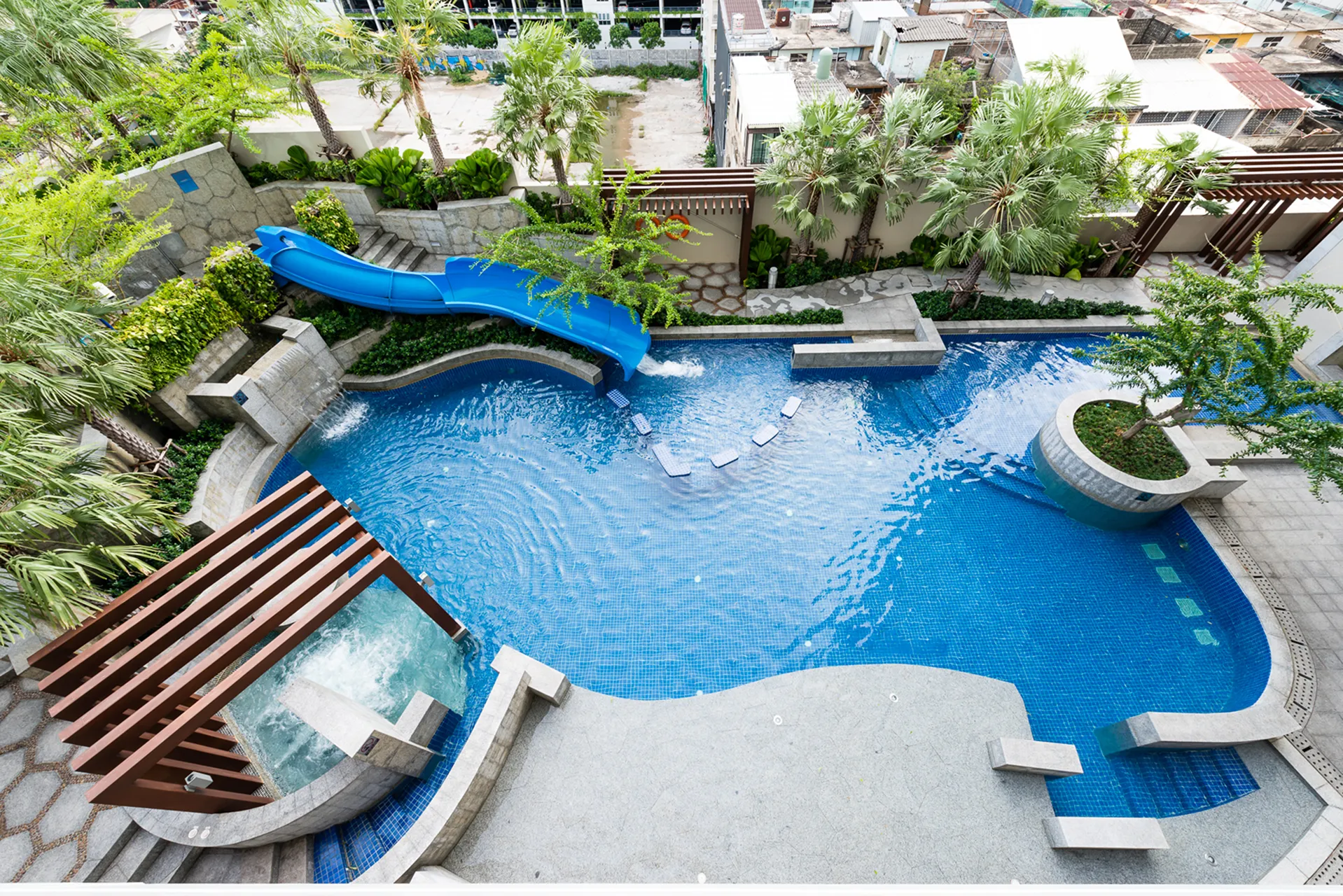 A swimming pool at a Bangkok hotel with a relaxing outdoor setting.