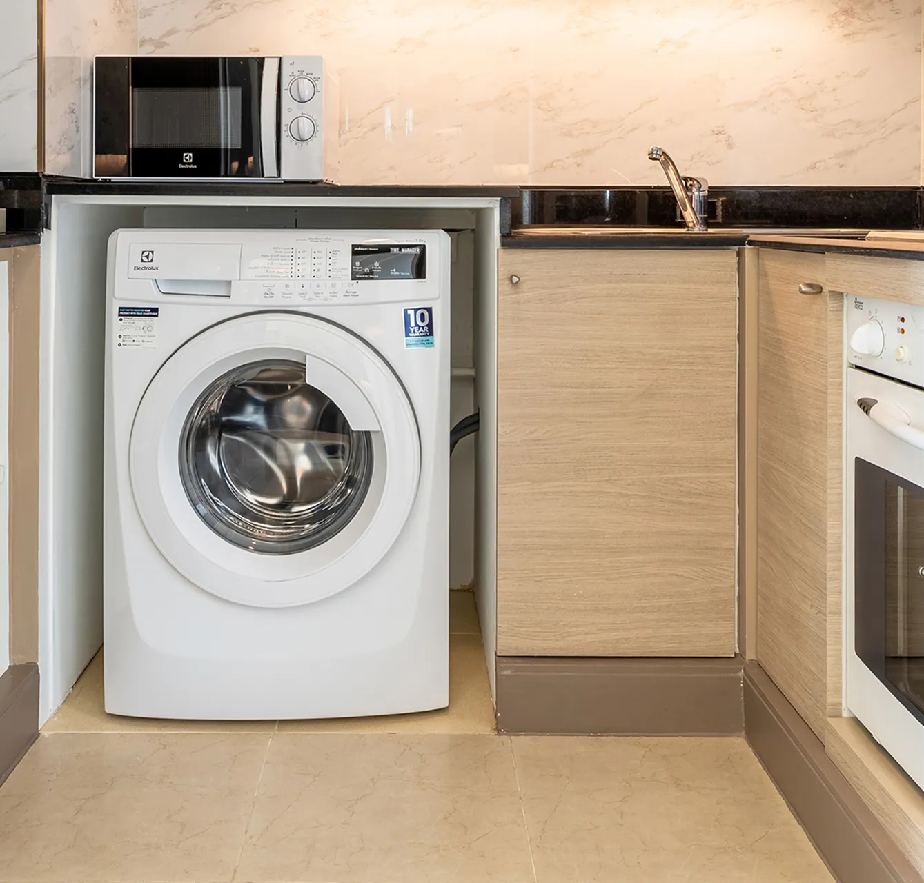 Private washing machine and kitchen facilities at a long-stay hotel in Bangkok.